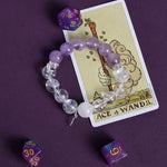 Purple and clear beaded bracelet with small dangling charm, stretch fit.