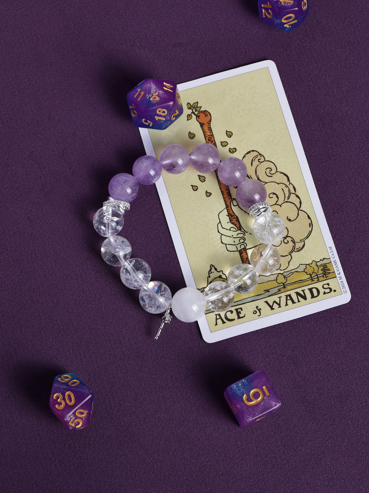 Purple and clear beaded bracelet with small dangling charm, stretch fit.