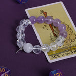 Lilac and clear gemstone-style bead bracelet with cross charm, elastic string.