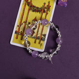 Purple and clear bead bracelet with silver spacers and small cross charm