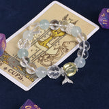 Light blue and clear beaded charm bracelet, featuring starfish and fish pendants