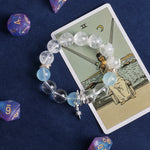 Clear and light blue bead bracelet with gold separators and two dangling charms