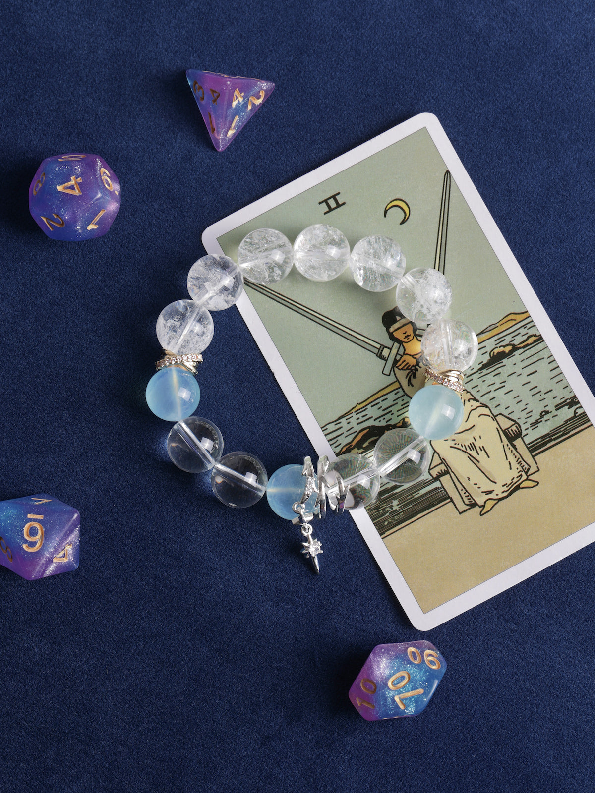 Clear and light blue bead bracelet with gold separators and two dangling charms