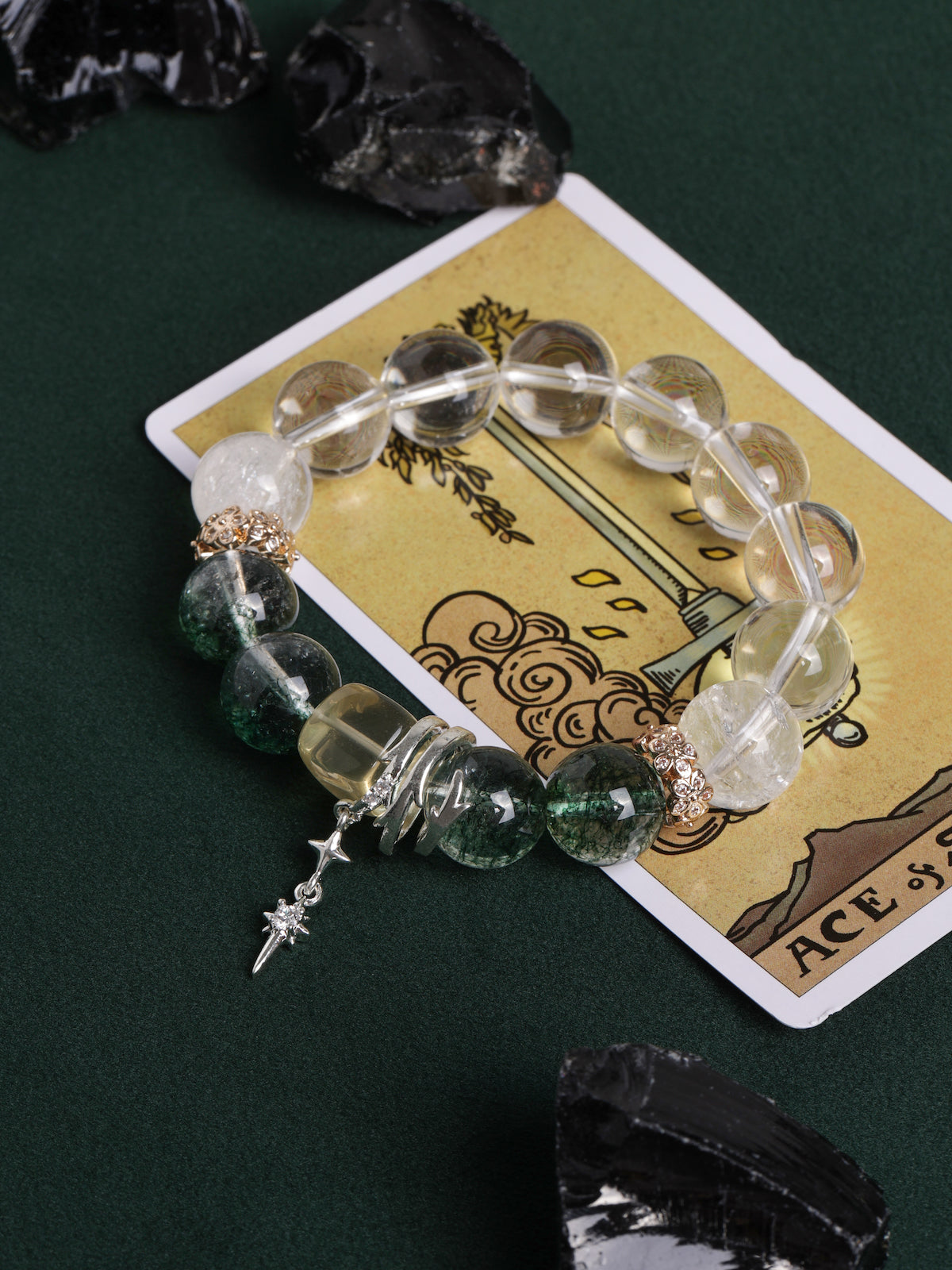 Beaded energy bracelet with clear beads, green stone beads, and dangling sword charm