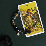 Beaded bracelet with clear and golden stones, black beads, and a dangling star charm