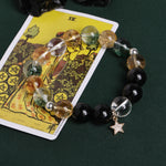 Beaded bracelet with smoky clear, golden, and black beads plus a star charm