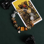 Gemstone bead bracelet featuring clear and gray beads, amber accents, gold spacer, star charm
