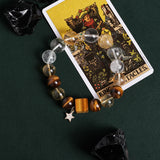 Gemstone bead bracelet featuring clear and gray beads, amber accents, gold spacer, star charm