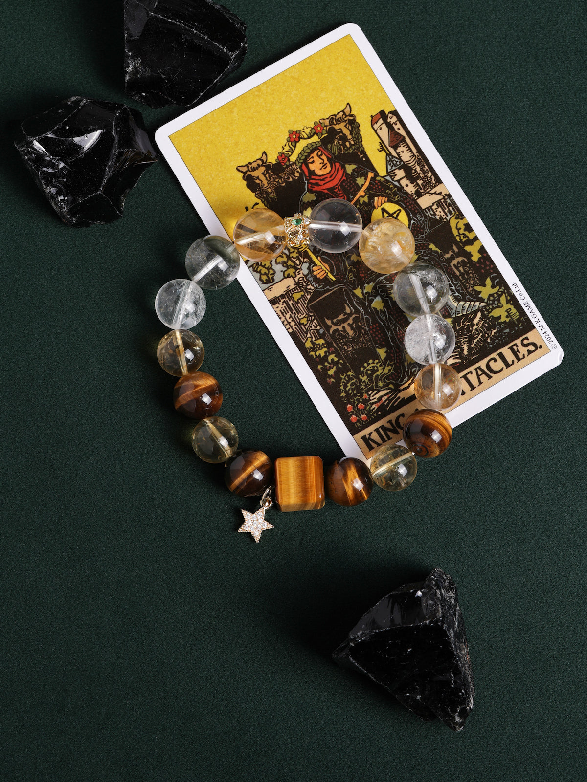 Gemstone bead bracelet featuring clear and gray beads, amber accents, gold spacer, star charm