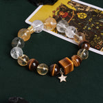 Gemstone bead bracelet with round clear and amber stones, gray beads, gold centerpiece, star charm