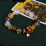 Gemstone bead bracelet with round clear and amber stones, gray beads, gold centerpiece, star charm