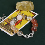 Crystal bead bracelet with mixed gray, clear, and orange/red stones, silver clasp heart links