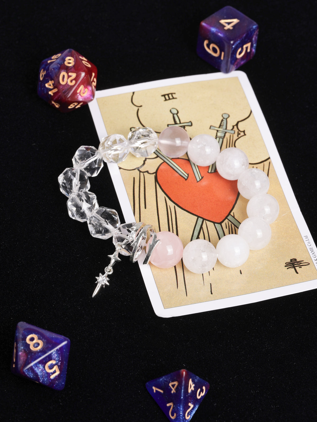 Crystal bead bracelet with clear and white-pink stones, dangling silver charm.