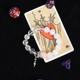 Crystal and bead bracelet with white, pink, and clear stones; silver star cross charm.