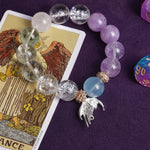 Beaded bracelet with clear, lilac, light-blue stones and gold-toned angel charm