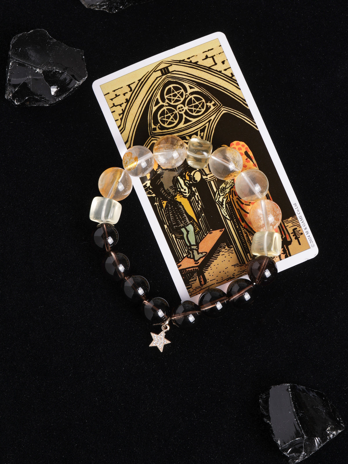 Beaded energy bracelet with translucent and dark round beads, plus hanging gold star charm