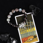Energy bracelet with smoky gray beads, black striped beads, and star cross charm