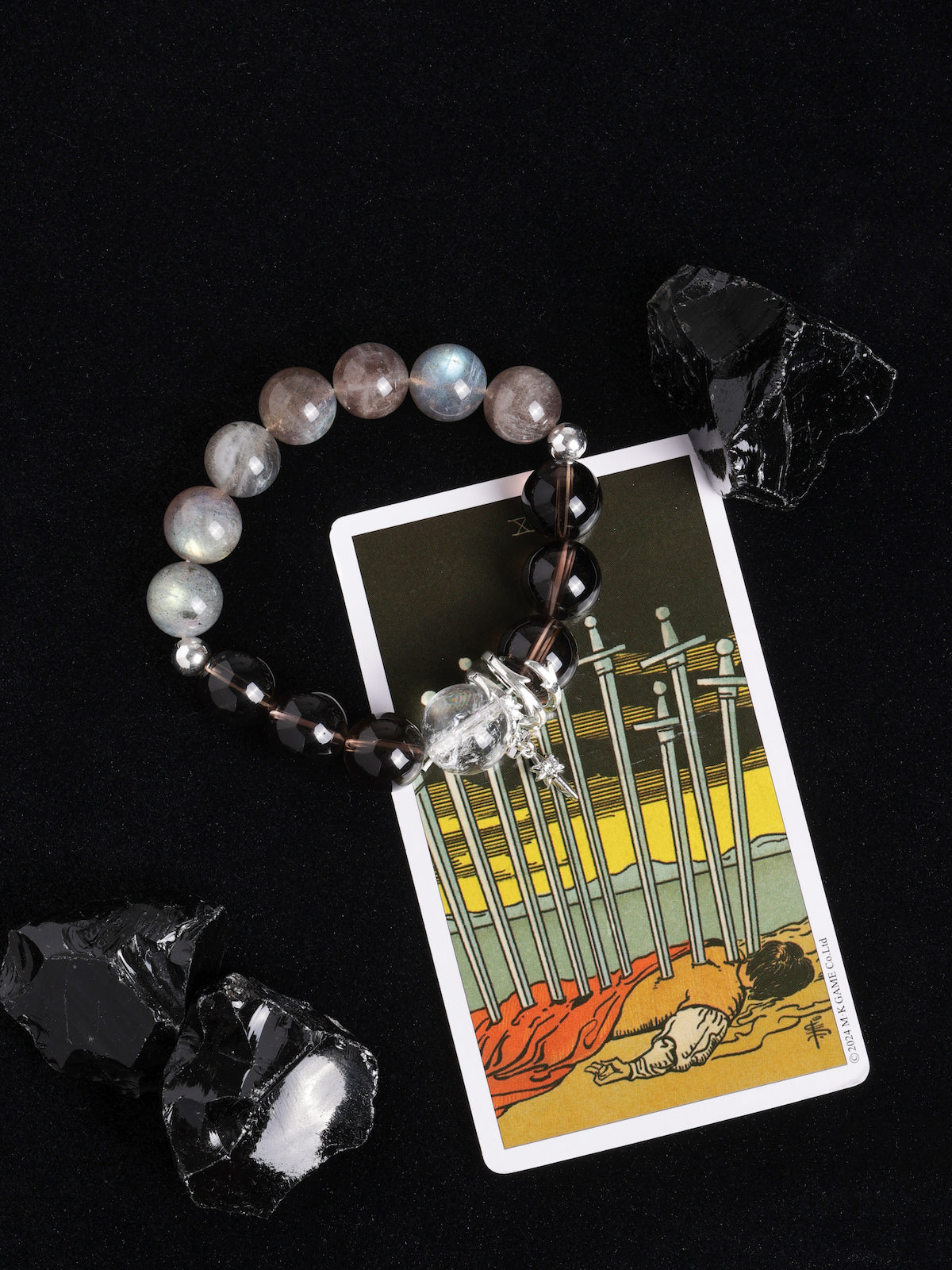 Energy bracelet with smoky gray beads, black striped beads, and star cross charm