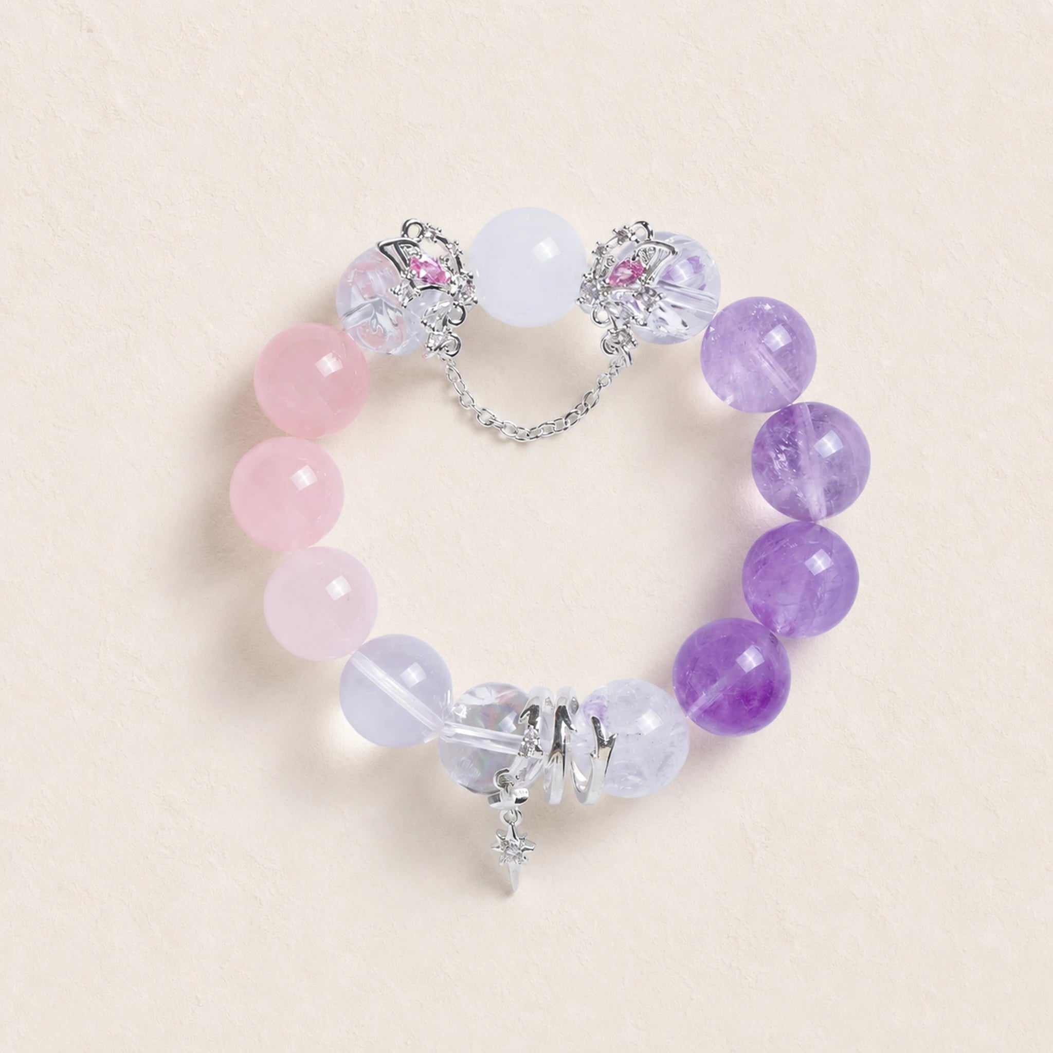 Beaded energy bracelet with pink, purple, and clear stones, silver chain and cross charm