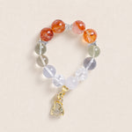 Beaded energy bracelet with orange and translucent gray beads, silver spacers, gold charm