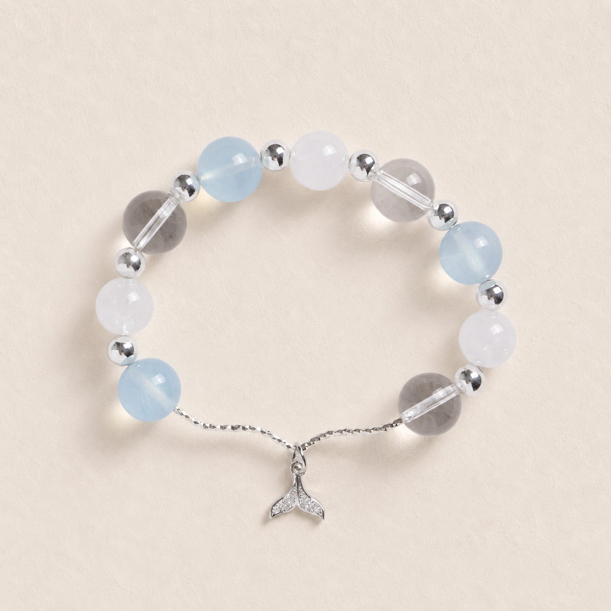 Silver-tone beaded bracelet with pale blue and white round beads, featuring a fish charm.