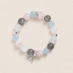 Pastel beaded bracelet with gray, pink, and blue stones; silver toggle and dangling charm.