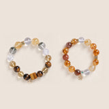 Gemstone beaded bracelet pair: clear, amber, and gray stones with gold-tone spacers