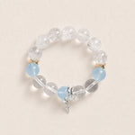 Beaded energy bracelet with clear stones, light blue accents, gold spacers, silver charm