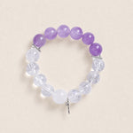 Beaded gemstone bracelet with purple and clear beads and a small dangling cross charm