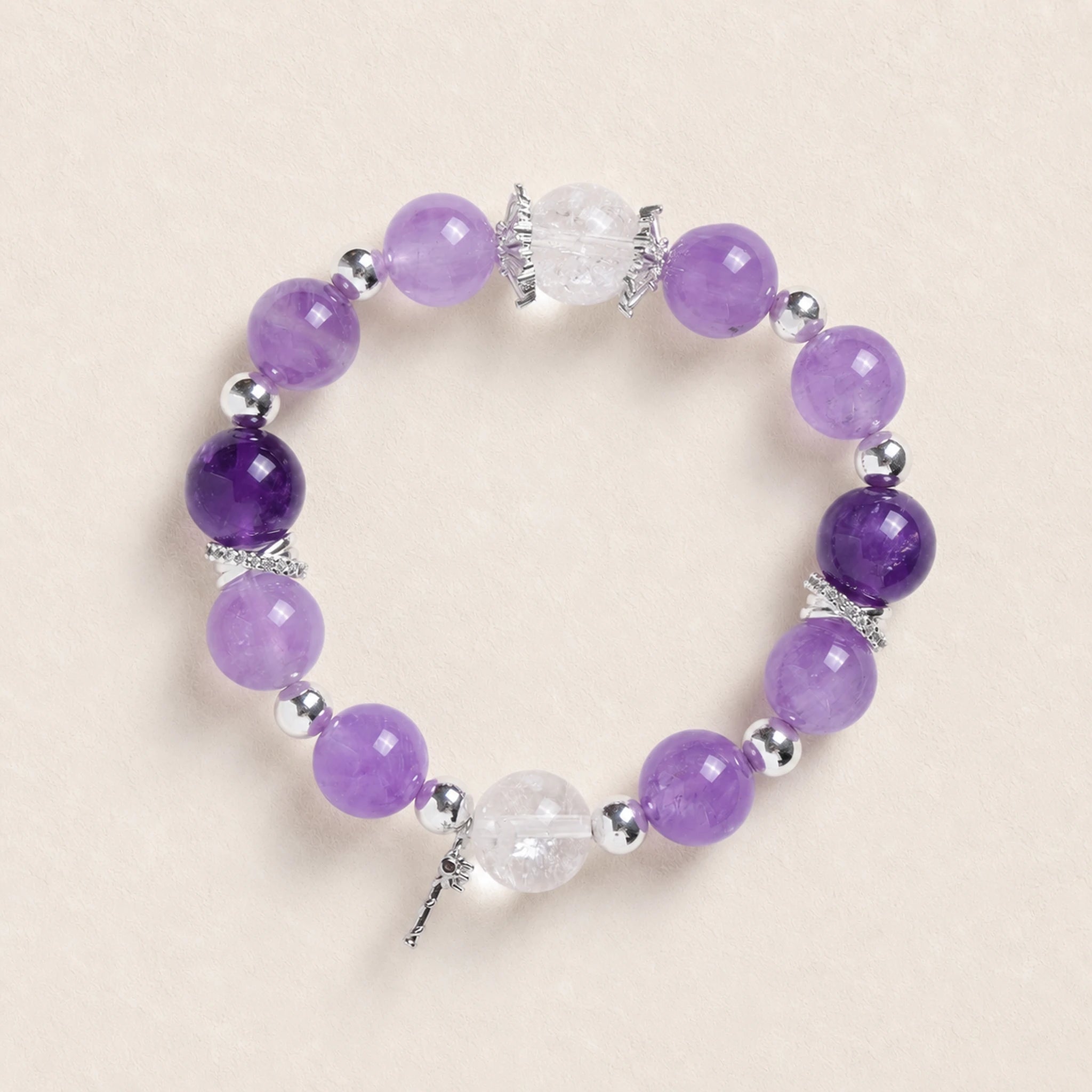 Purple amethyst-style bead bracelet with silver spacers and clear faceted charm
