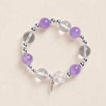 Purple and clear bead energy bracelet with silver spacers and small dangling charm