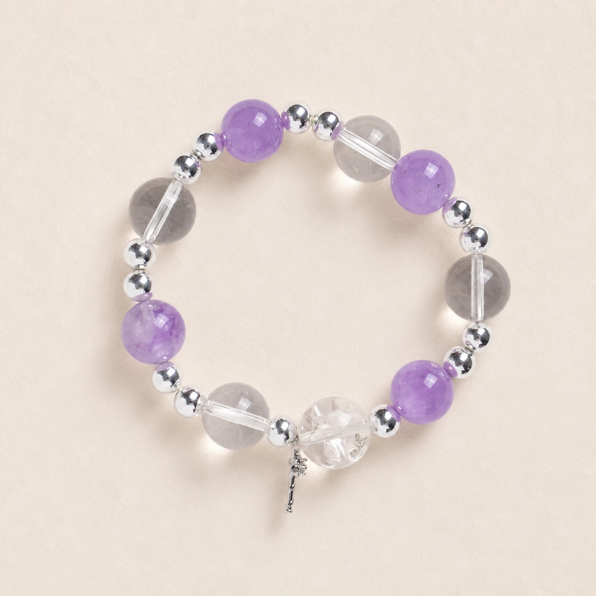 Purple and clear bead energy bracelet with silver spacers and small dangling charm
