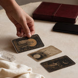 Tarot cards on a table with a hand turning one card
